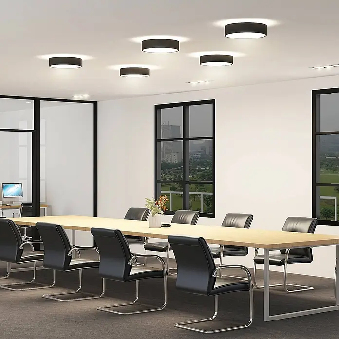 Arcchio Deckenleuchte Vanida - schwarz, schwarz - Schwarze zylindrische Deckenleuchten beleuchten einen modernen Konferenzraum mit langem Tisch und Stühlen.