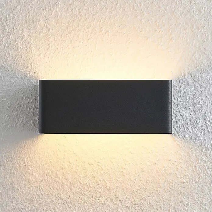 Arcchio Wandleuchte Karam - L x B x H: 10 x 20 x 8 cm, schwarz, schwarz - Dunkelgraue rechteckige Up-Down-Wandleuchte wirft warmes Licht auf eine strukturierte Wand.