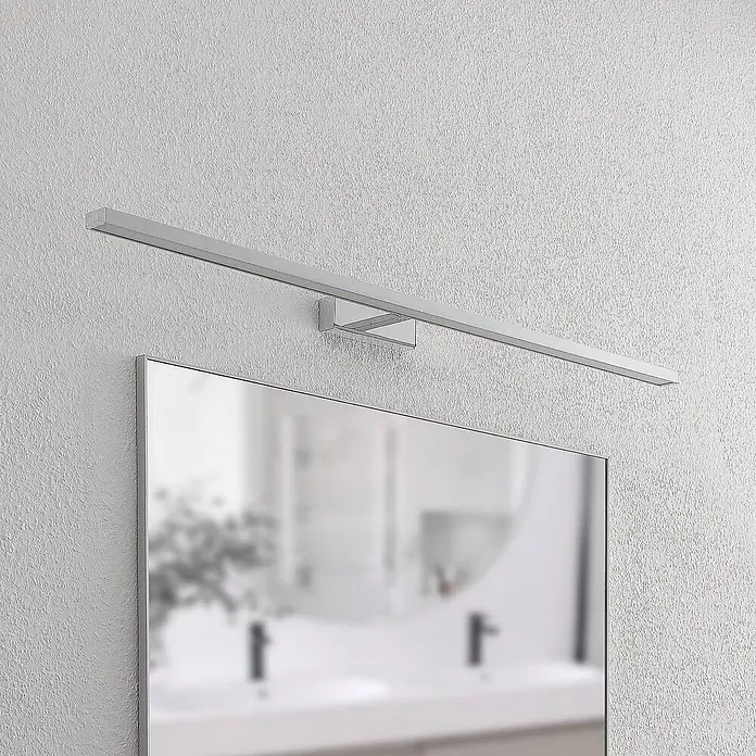Lindby Wandleuchte Jukka - chrom / silber - Silberne lineare LED-Spiegelleuchte über einem Spiegel montiert.
