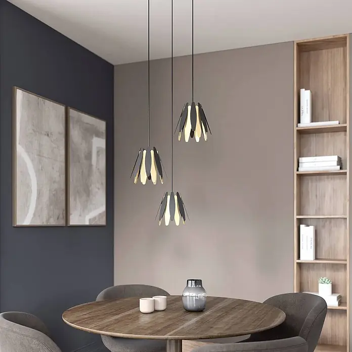 Lucande Pendelleuchte Lounit - L x B x H: 50 x 50 x 150 cm, schwarz, Schwarz, gold, E14 - Drei moderne Pendelleuchten mit dunkelgrauen und hellen Segmenten, die einen runden Esstisch in einem zeitgenössischen Raum beleuchten.