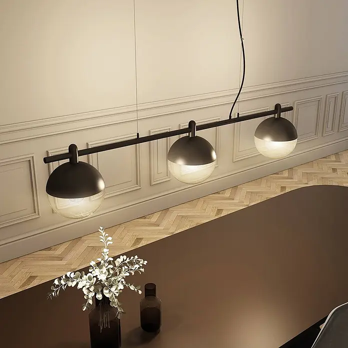 Lucande Pendelleuchte Dustian - klar, Schwarz, E27 - Schwarze lineare Pendelleuchte mit drei Glaskugel-Lampen über einem Esstisch.