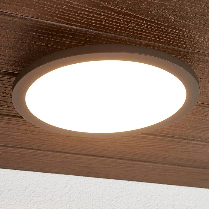 Lucande Außenwand- & Deckenleuchte Malena - schwarz, IP65 - Rundes, dunkelbraunes Unterputz-LED-Deckenlicht, befestigt an einer strukturierten Holzplatte, spendet hellweißes Licht.