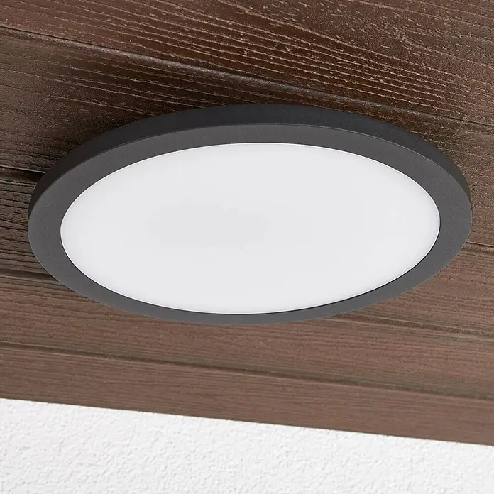 Lucande Außenwand- & Deckenleuchte Malena - schwarz, IP65 - Runde anthrazitfarbene LED-Deckenleuchte mit weißem Diffusor, an einer dunklen Holzdecke montiert.