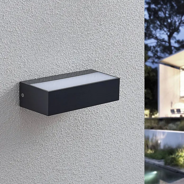 Lindby Außenwandleuchte Nienke - schwarz, schwarz, IP65 - Rechteckige dunkelgraue LED-Außenwandleuchte an strukturierter Wand, beleuchtet die Außenanlage in der Dämmerung.