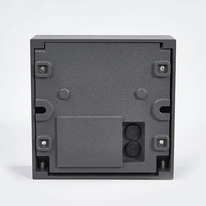 Lucande Außenwandleuchte Dijora - 3,1 x 9,5 x 9,5 cm, schwarz, IP65 - Rückansicht einer dunkelgrauen, strukturierten quadratischen Montagebasis für Außenbeleuchtung mit Befestigungsschrauben und Kabeldurchführungen.