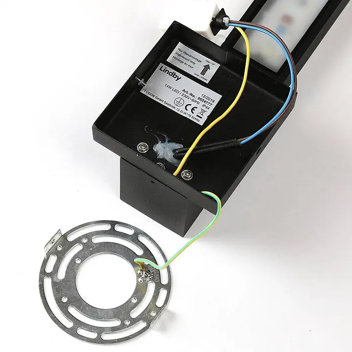 Lindby Außenwandleuchte Isadore - schwarz, schwarz, IP44 - Schwarze LED-Wandleuchte mit sichtbarer Innenverdrahtung, einem Spezifikationsetikett und einem separaten silbernen Montagebügel.