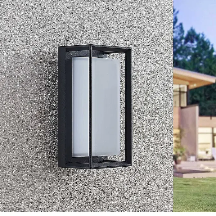 Arcchio Außenwandleuchte Ismera - schwarz, schwarz, IP65 - Schwarze Außenwandleuchte aus Metall mit rechteckigem Mattglasdiffusor an einer strukturierten Hauswand.