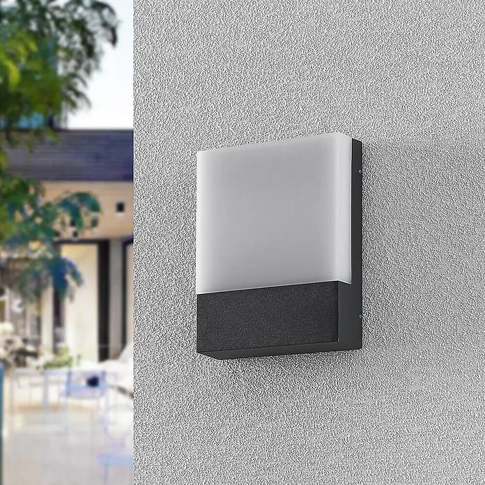 Lindby Außenwandleuchte Vanira - schwarz, IP54 - Moderne rechteckige Außenwandleuchte mit dunkelgrauem Sockel und milchweißem Diffusor, an der Wand montiert.