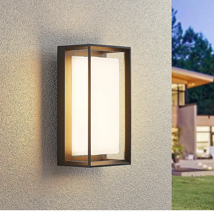 Arcchio Außenwandleuchte Ismera - schwarz, schwarz, IP65 - Schwarze rechteckige Außenwandleuchte mit weißem Diffusor, an einer strukturierten Wand montiert.