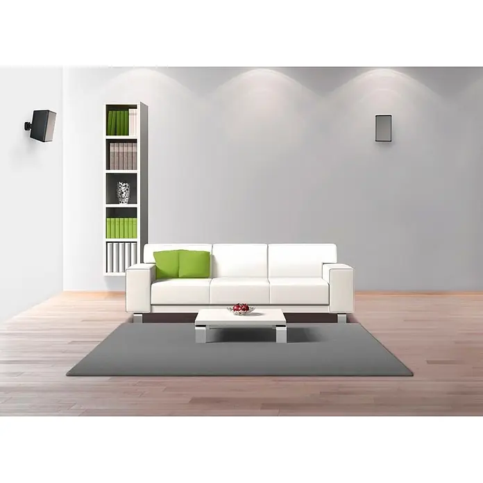Hama Wandhalter 00220887 Lautsprecher-Wandhalterung neigbar schwenkbar - Schwarz - Moderner weißer Couch, weißer Couchtisch und grauer Teppich bilden einen minimalistischen Wohnbereich mit grünen Akzentkissen.