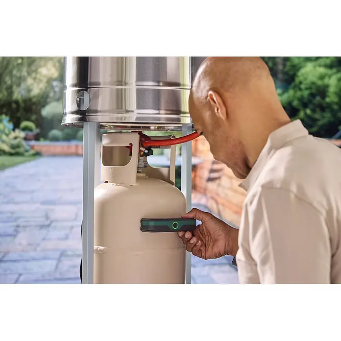 Bosch Gasflaschen-Füllstandsanzeiger Filio - Passend für: Stahl- und Aluminium-Flüssiggasflaschen (Propan und Butan) mit einem Durchmesser von 200-350 mm - Mann benutzt dunkelgrünen und schwarzen Gasfüllstandsanzeiger an beiger Gasflasche für einen Terrassenheizer.