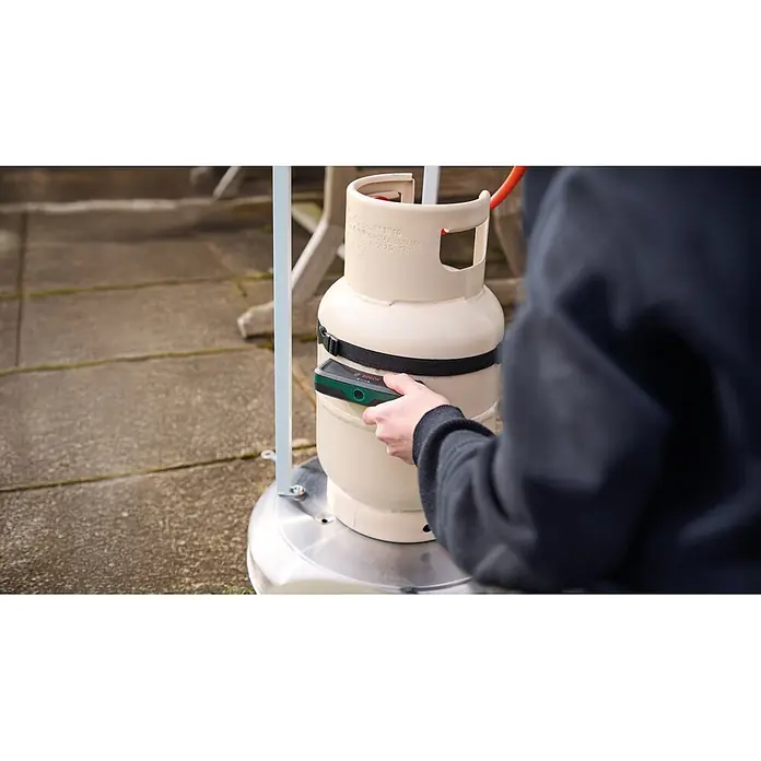Bosch Gasflaschen-Füllstandsanzeiger Filio - Passend für: Stahl- und Aluminium-Flüssiggasflaschen (Propan und Butan) mit einem Durchmesser von 200-350 mm - Person befestigt Bosch Gasfüllstandsanzeiger an beiger Gasflasche für einen Terrassenheizer.