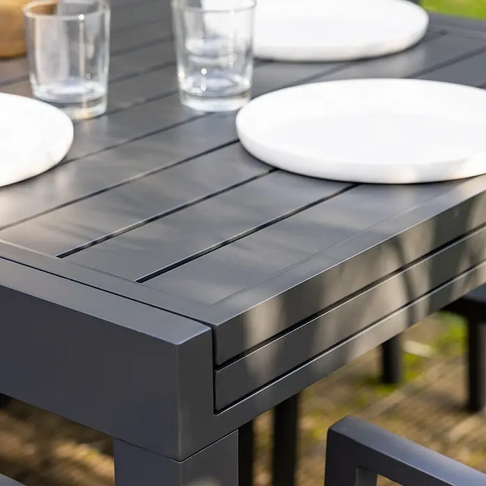 Happy Garden Gartentisch-Set VENEZIA - Gesamtumfang: 11 -tlg., Aluminium - Dunkelgrauer Lamellen-Gartentisch aus Metall, mit weißen Tellern und Gläsern gedeckt.