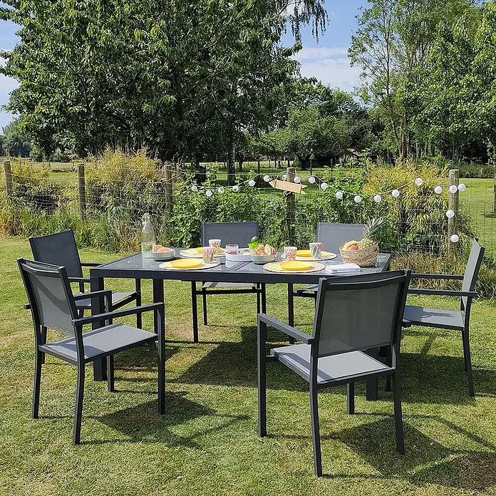 Happy Garden Gartentisch-Set FIRENZE - Gesamtumfang: 9 -tlg., Aluminium - Dunkelgraue Outdoor-Essgruppe mit Tisch und sechs Stühlen auf grünem Rasen für eine Mahlzeit im Freien.