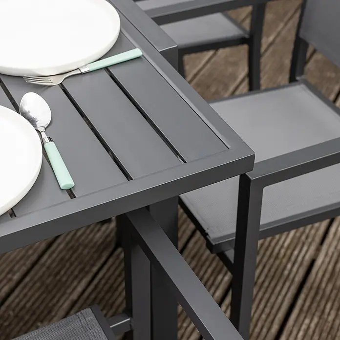 Happy Garden Gartentisch-Set VENEZIA - Gesamtumfang: 9 -tlg., Aluminium - Dunkelgrauer Metall-Gartentisch mit Lattenplatte, gedeckt mit weißen Tellern und mintgrünem Besteck, neben passendem Stuhl.
