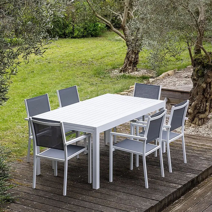 Happy Garden Gartentisch-Set VENEZIA - Gesamtumfang: 11 -tlg., Aluminium - Weißer Gartentisch mit Lattenplatte und sechs Stühlen mit weißen Gestellen und grauen Netzsitzen, auf einer Holzterrasse.