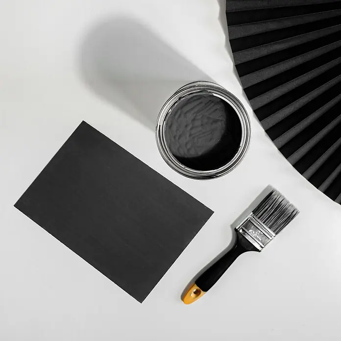 Creative Deco Speziallack Kreidefarbe für Möbel Anthrazitgrau - Grau, Matt, 1 l, Wasserbasiert - Offene Dose schwarzer Farbe, ein Pinsel und ein Stück schwarz gestrichenes Papier, bereit zum Gebrauch.