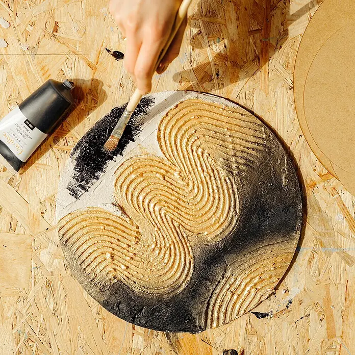 Creative Deco Speziallack Strukturpaste Feinkörnig 1 kg Weiß - Weiß, Sonstiges, Sonstiges - Hand bemalt ein kreisförmiges strukturiertes Kunstwerk mit Gold- und Schwarzfarbe auf Holz.