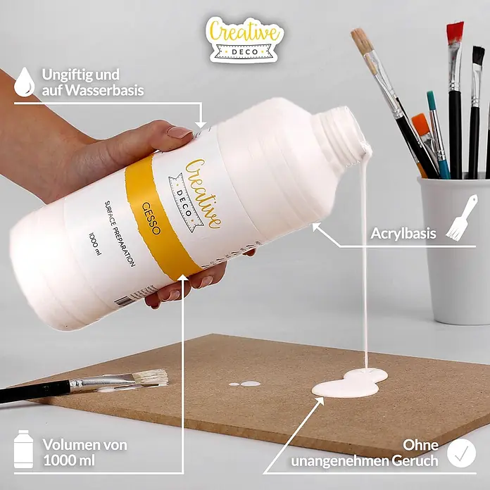 Creative Deco Speziallack Gesso Weiß 1000ml - Weiß, 1 l, Wasserbasiert - Eine Hand gießt weißes Gesso aus einer 1000-ml-Flasche auf eine Holzplatte, daneben Pinsel. Das Gesso ist auf Wasser- und Acrylbasis.