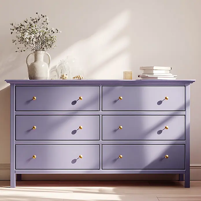 Creative Deco Speziallack Kreidefarbe für Möbel Violett - Violett, Matt, 1 l, Wasserbasiert - Eine hellviolette Kommode mit sechs Schubladen und runden Goldknöpfen in einem sonnigen Raum.
