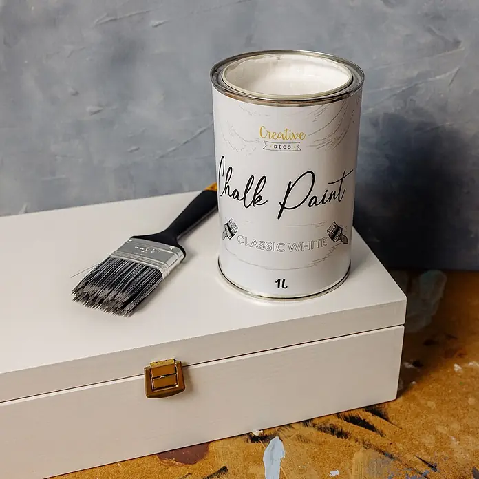 Creative Deco Speziallack Kreidefarbe für Möbel Weiß - Weiß, Matt, 1 l, Wasserbasiert - Offene Dose klassisch-weißer Kreidefarbe mit Pinsel auf einer weißen Holzkiste.