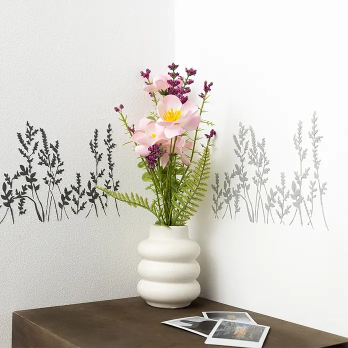 Creative Deco Speziallack Strukturpaste Feinkörnig 2 kg Grau - Grau, Sonstiges, 2 l, Sonstiges - Weiß gerippte Keramikvase mit künstlichen rosa und lila Blumen auf einem dunklen Holzregal vor einer weißen Wand mit Pflanzenmotiven.