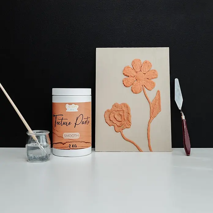 Creative Deco Speziallack Strukturpaste Glatt 2 kg Ziegelrot - Rot, Sonstiges, 2 l, Sonstiges - Ein Glas mit Pfirsich-Strukturpaste steht neben einer Leinwand mit Textur-Blumenkunst. Pinsel in Wasser und Spachtel ergänzen das Kunst-Setup.