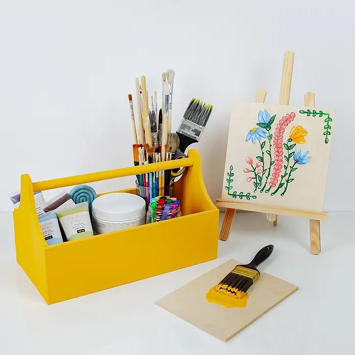 Creative Deco Speziallack Kreidefarbe für Möbel Orange - Orange, Matt, 1 l, Wasserbasiert - Gelber Malkasten mit Farben und Pinseln, eine Staffelei mit bemaltem Brett und ein Pinsel mit gelber Farbe auf Holz.
