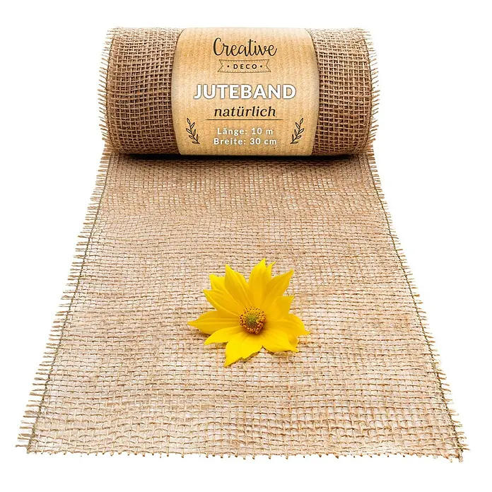 Creative Deco Bastelband Juteband 30cm x 10m - Braun - Eine Rolle natürliches Juteband, 30 cm breit und 10 m lang, mit gewebter Textur, teilweise abgerollt, mit einer gelben Blume darauf.