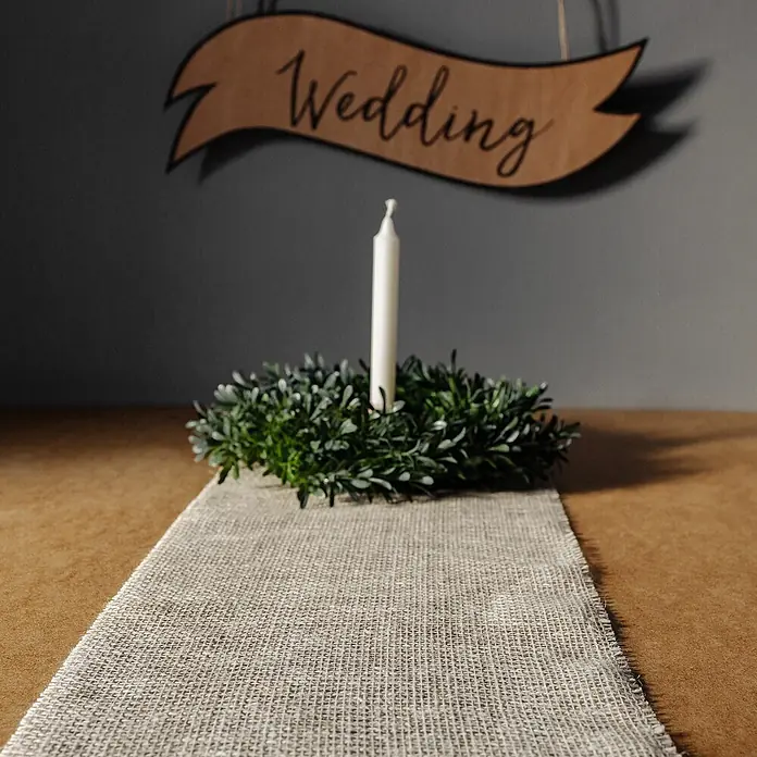 Creative Deco Bastelband Juteband Weiß 30cm x 10m - Weiß, 10 m - Tischläufer aus Naturleinen mit sichtbarer Webstruktur, auf einem Holztisch als Hochzeitsdekoration.