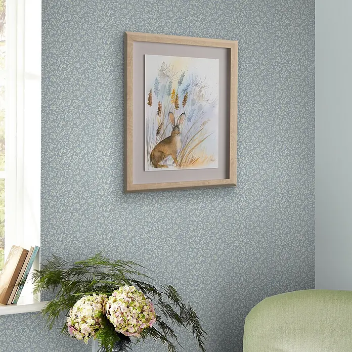 Laura Ashley Vliestapete Vliestapete Süßes Alyssum - Hellblau, Floral, 10 x 0,52 m - Hellblaue Tapete mit cremefarbenem Blumen- und Rankenmuster in einem Wohnraum.