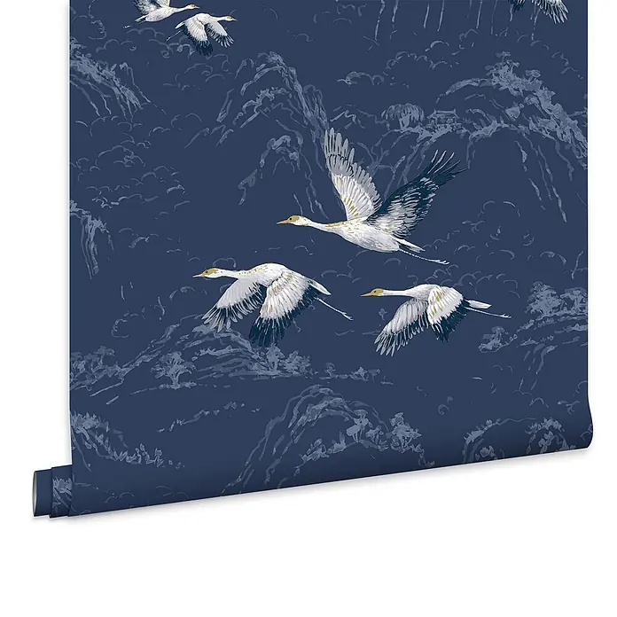 Laura Ashley Vliestapete Animalia - Dunkelblau, Tieroptik, 1.000 x 52 cm - Dunkelblaue Tapetenrolle mit fliegenden weißen und goldenen Kranichen über grauen Bergen.