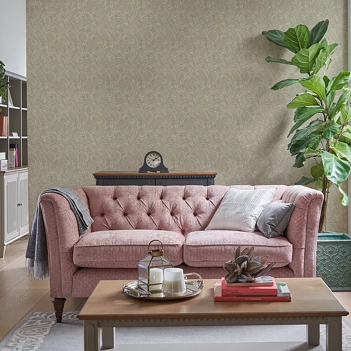 Laura Ashley Vliestapete Gerstenpflanzen - Beige, Floral, 1.000 x 52 cm - Botanisch gemusterte Tapete in warmem Beigeton, die einen sanften Hintergrund für ein gemütliches Wohnzimmer mit rosa Sofa und Couchtisch bildet.