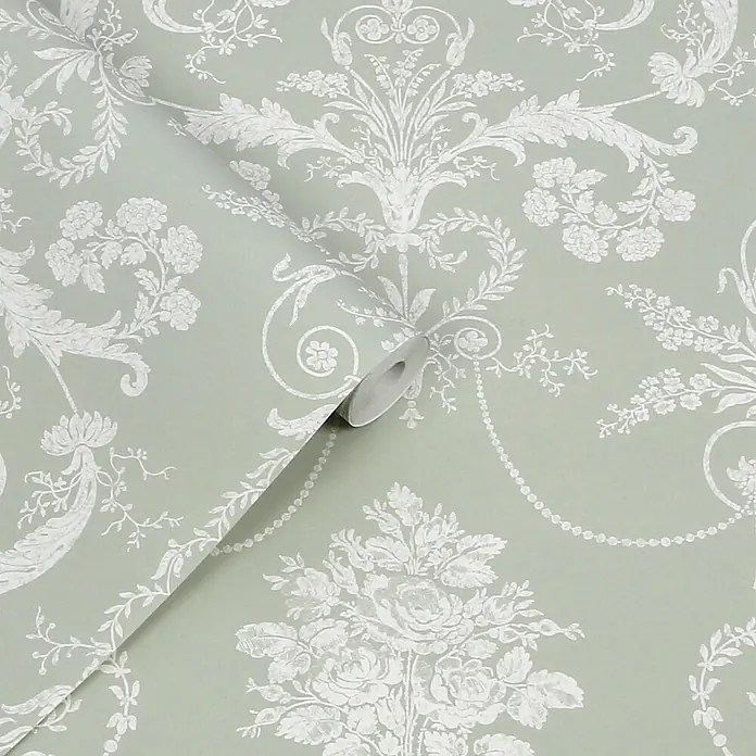 Laura Ashley Vliestapete Josette Damast - Grün, Ornament, 1.000 x 52 cm - Hellgrüne Tapete mit weißen Blumen- und Damastmustern, teilweise abgerollt, um das Design zu zeigen.