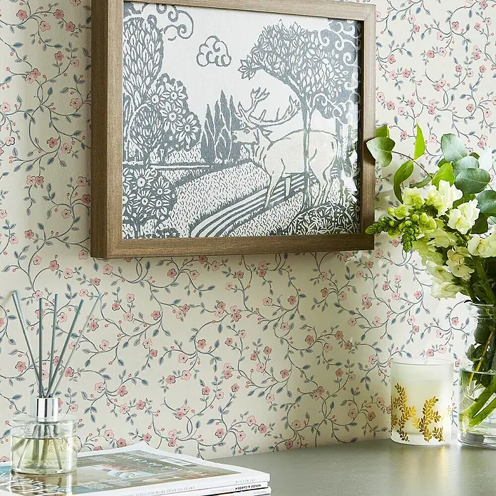 Laura Ashley Vliestapete Vliestapete Belncow Sprig - Hellblau, Floral, 10 x 0,52 m - Helle Tapete mit zartem rosa Blumen- und grünem Rankenmuster, schmückt eine Zimmerwand.