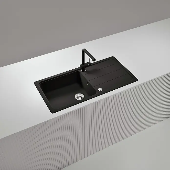 Schock Einbauspüle Formhaus - 100 x 50 cm, Nero, Quarzkomposit - Eine schwarze Küchenspüle mit integriertem schwarzem Wasserhahn in einer weißen Arbeitsplatte. Verfügt über einen Chromablauf und eine gerillte Abtropffläche.