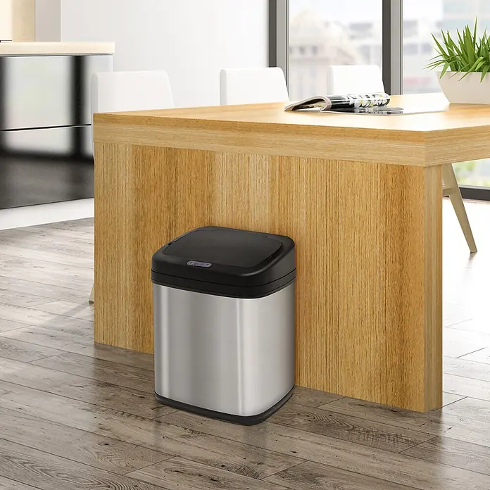 Homcom Sensormülleimer 1-teilig - 20 l, Edelstahl, Silber - Mülleimer aus Edelstahl mit schwarzem Sensor-Deckel, neben einem modernen Holztisch.