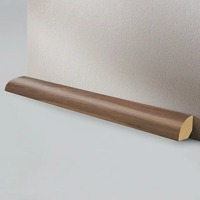 LOGOCLIC Viertelstab Nussbaum - 260 cm x 22 mm x 22 mm, MDF - Nahaufnahme einer Viertelstab-Fußleiste aus Holz, die einen sauberen Übergang zwischen Wand und Boden bildet.