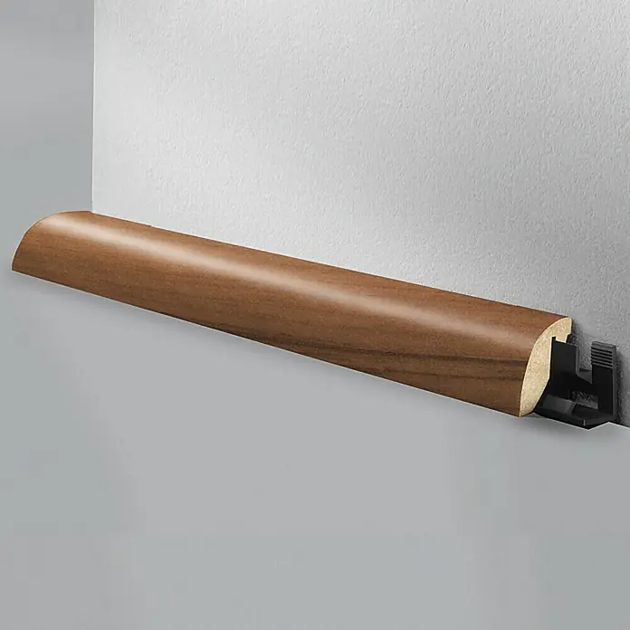 LOGOCLIC Viertelstab Noce Como - 260 cm x 23 mm x 29 mm, MDF - Holzsockelleiste mit Clip zur einfachen Montage an einer grauen Wand. Ideal für Laminat- und Parkettböden.