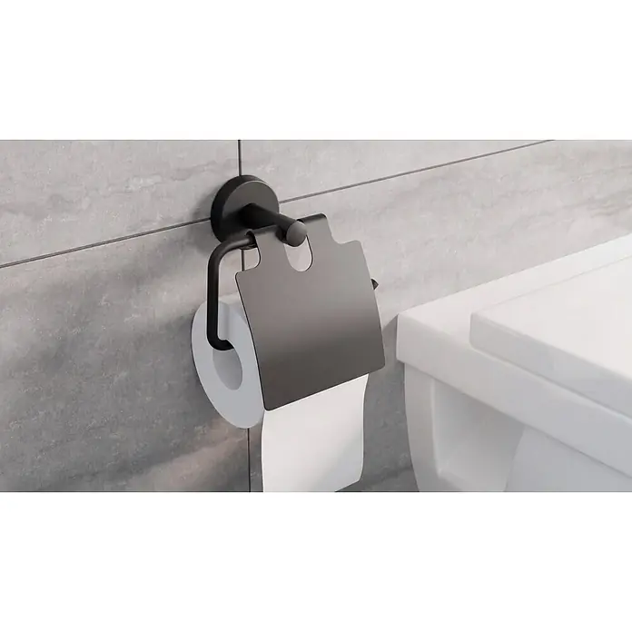 Camargue Paris Black Toilettenpapierhalter - L x B x H: 16,5 x 14 x 7 cm, Edelstahl, Schwarz - Schwarzer Toilettenpapierhalter mit Schutzabdeckung, an einer grauen Fliesenwand neben einer weißen Toilette montiert.