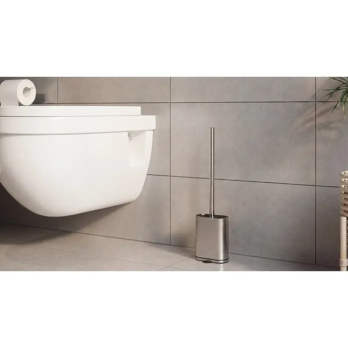 Camargue Antwerpen WC-Bürstengarnitur - Edelstahl, Edelstahl, Form: Oval - Toilettenbürste und Halter aus Edelstahl in einem modernen Bad neben einer wandhängenden Toilette.