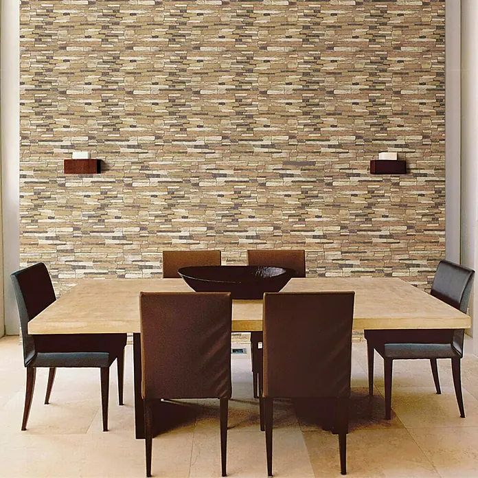 Verblendstein Aitana Marron - 50 x 33,5 cm, Braun, Steinoptik - Elegantes Esszimmer mit einem rechteckigen Holztisch und Stühlen mit dunklem Lederbezug, vor einer Wand mit Steinmuster.