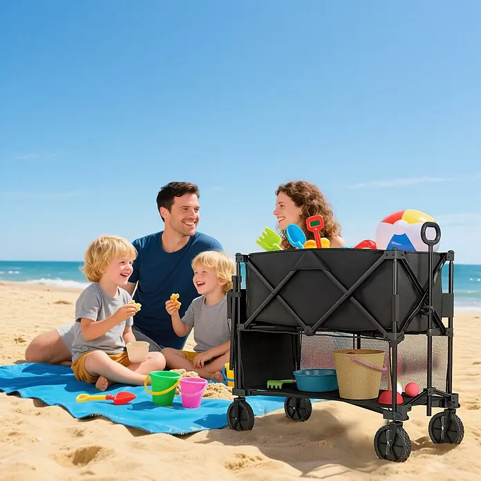 Outsunny Bollerwagen - L x B x H: 142 x 50 x 102 cm, Traglast: 200 kg, Stahl - Schwarzer faltbarer Strandwagen auf Sand, beladen mit bunten Spielsachen. Eine Familie im Hintergrund genießt den Strandtag.