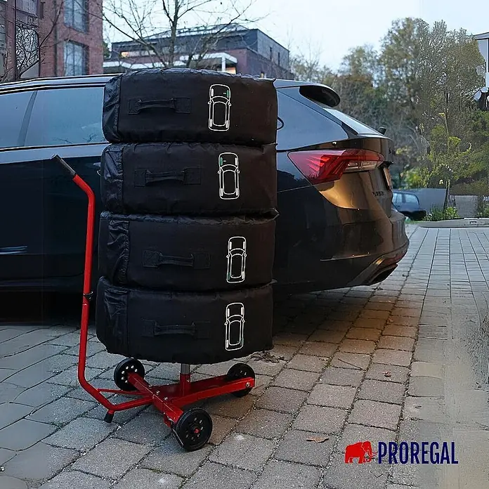 Proregal Reifenregal Fahrbarer Felgenbaum CARRERO - Stecken, Rot - Roter Reifenwagen mit vier schwarzen Reifen-Aufbewahrungstaschen, neben einem dunklen Auto gestapelt.