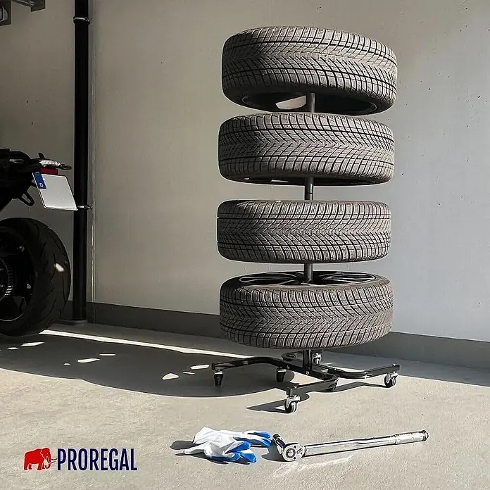 Proregal Reifenregal Fahrbarer Felgenbaum CARRERO - Stecken, Schwarz - Schwarzes Reifenregal auf Rollen, ordentlich vier Autoreifen in einer Garage lagernd.