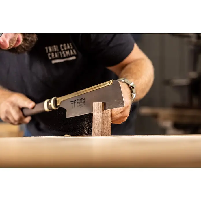Temple Tool Japansäge Dozuki Rip Cut - Blattlänge: 240 mm - Ein Handwerker verwendet eine Messingrücken-Zugsäge mit dunklem Griff, um eine Holzverbindung präzise zu schneiden.