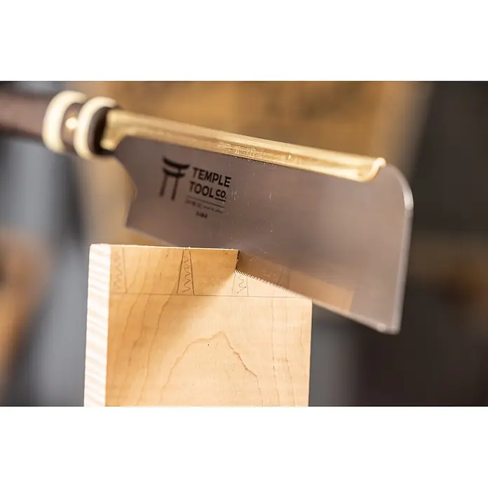 Temple Tool Japansäge Dozuki Rip Cut - Blattlänge: 240 mm - Temple Tool Co. Zinkensäge mit messingfarbenem Rücken und dunklem Griff, schneidet ein Schwalbenschwanzblatt in helles Holz.