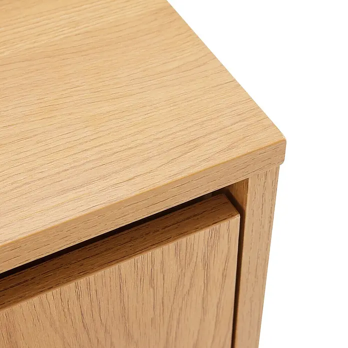Happy Garden Kommode SARAH - Helles Holz - Nahaufnahme eines hellen, eichenfarbenen Möbelstücks aus Holz, das die Oberseite und eine Schubladenfront mit natürlicher Holzmaserung zeigt.
