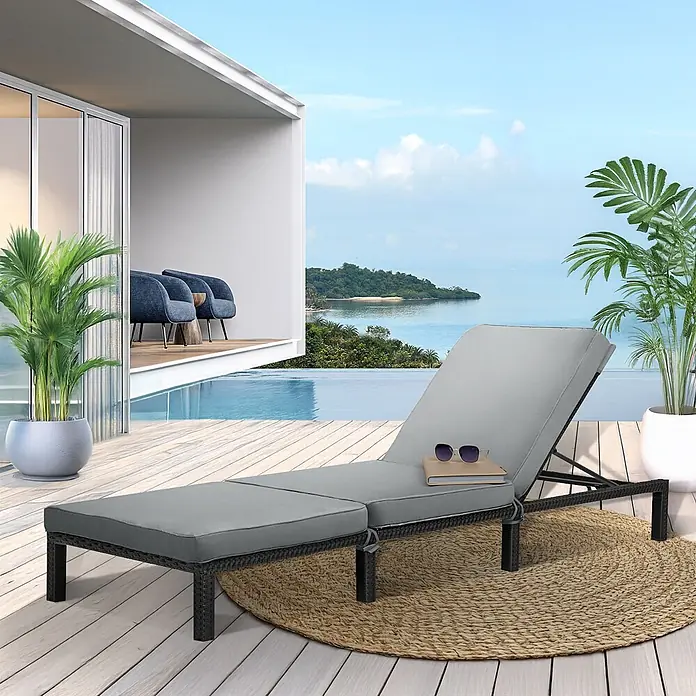 SVITA Gartenliegen-Set - B x T: 66 x 196 cm, Schwarz, Metall, Rückenlehne verstellbar - Graue Outdoor-Chaiselongue mit schwarzem Korbgeflechtgestell auf einer Holzterrasse an einem Infinity-Pool, Meer im Hintergrund, mit Buch und Sonnenbrille.