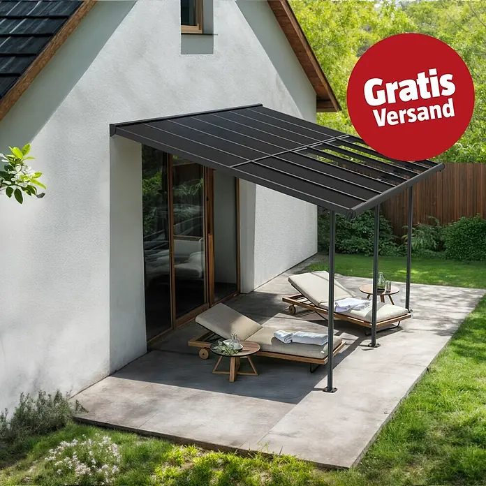 Palram – Canopia Terrassenüberdachung Sierra Cabrio - B x T: 430 x 300 cm, Anthrazitgrau, Polycarbonat, Grau - Dunkelgraue Terrassenüberdachung am weißen Haus, die eine Terrasse mit zwei Liegestühlen überdacht.